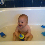Practicing with the sippy cup in the bath.