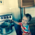 toddler standing on table and stirring stew