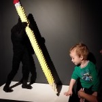toddler with pencil lego sculpture