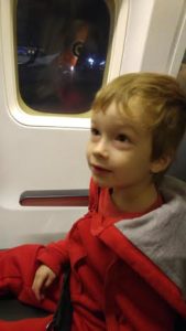 child sitting next to window of plane